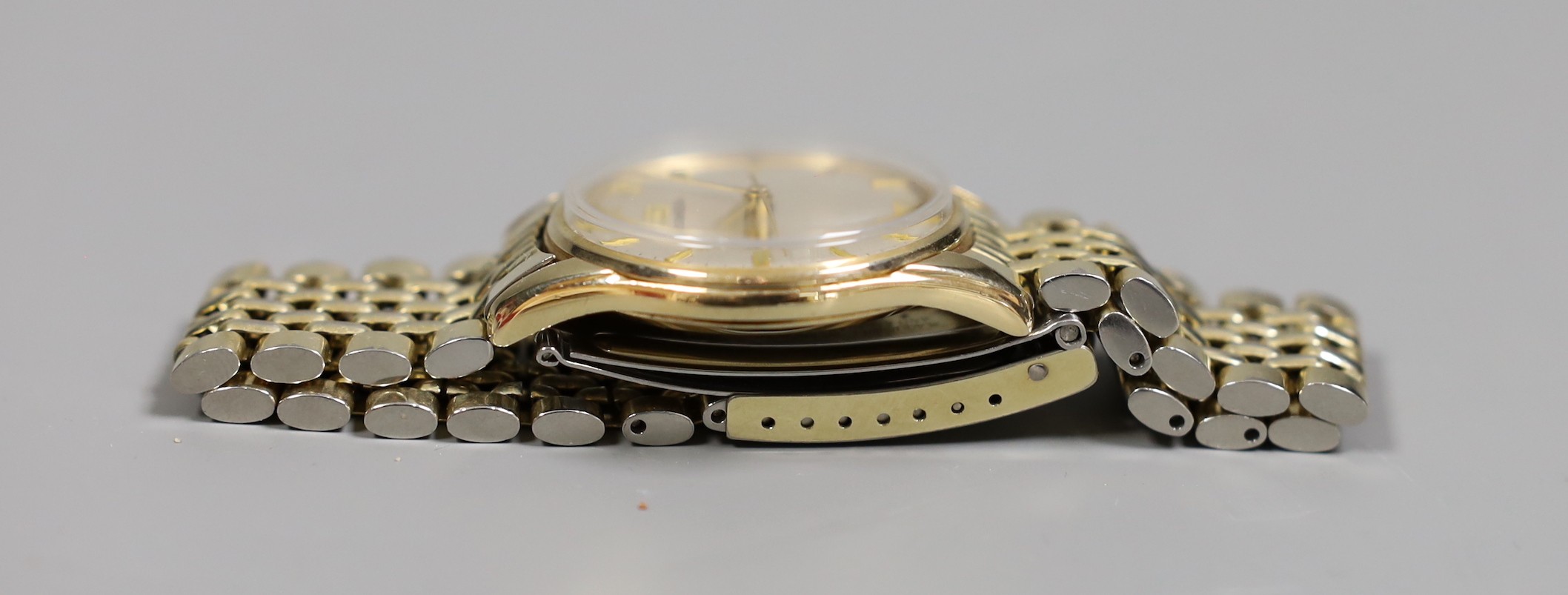 A gentleman's 9ct gold Omega manual wind wrist watch, on an Omega steel and gold plated bracelet, with box and pamphlets.